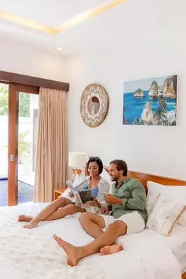 a man and woman sitting on a bed at Casa Amore Villa in Berawa Beach - Canggu in Canggu