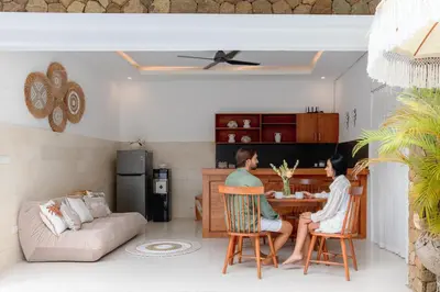 two people sitting at a table in a living room at Casa Amore Villa in Berawa Beach - Canggu in Canggu