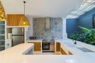 a kitchen with white counters and a blue wall at Berawa -Ocean View 5 Bed, Walk to Beach, Sleeps 10 in Canggu