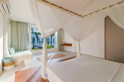 a bedroom with a bed with a canopy at Berawa -Ocean View 5 Bed, Walk to Beach, Sleeps 10 in Canggu