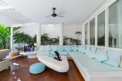 a living room with a white couch and blue pillows at Berawa -Ocean View 5 Bed, Walk to Beach, Sleeps 10 in Canggu