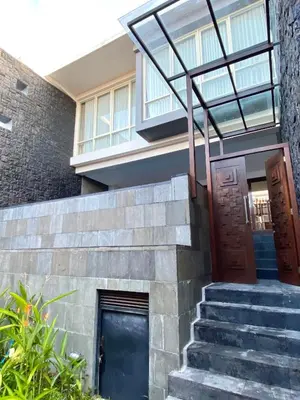 a house with a glass door and stairs at Bloomingville Villas in Nusa Dua in Nusa Dua