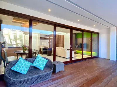 a living room with a couch with blue pillows at Bloomingville Villas in Nusa Dua in Nusa Dua