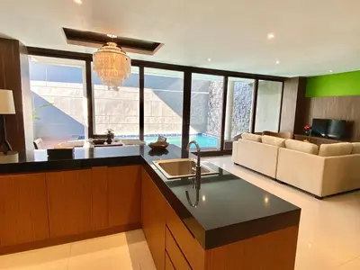 a kitchen with a sink and a living room at Bloomingville Villas in Nusa Dua in Nusa Dua