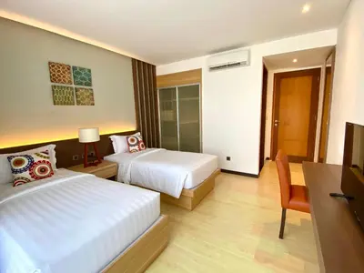 a hotel room with two beds and a television at Bloomingville Villas in Nusa Dua in Nusa Dua