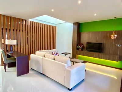 a living room with a white couch and a tv at Bloomingville Villas in Nusa Dua in Nusa Dua