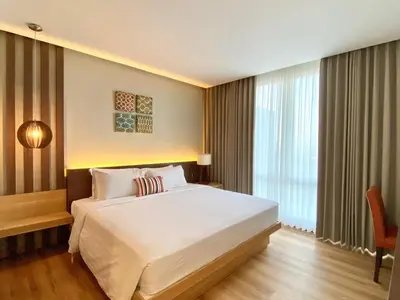 a bedroom with a large white bed and a window at Bloomingville Villas in Nusa Dua in Nusa Dua
