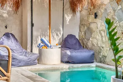 a swimming pool with two blue bean bags next to it at Tropical and Minimalist 2bd Umalas Villa with Private Pool in Canggu