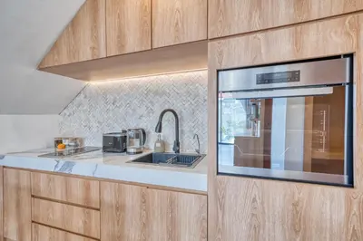 a kitchen with a sink and a microwave at Tropical and Minimalist 2bd Umalas Villa with Private Pool in Canggu