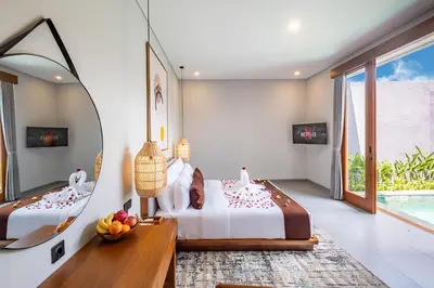 two beds in a room with a mirror at Karaya Villas Umalas - Free In-Villa Culture Immersion Programs in Kerobokan