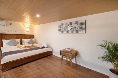 a bedroom with a bed and a table with a plant at Cozia Living in Jimbaran