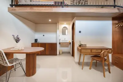 a kitchen with a table and chairs and a desk at Cozia Living in Jimbaran
