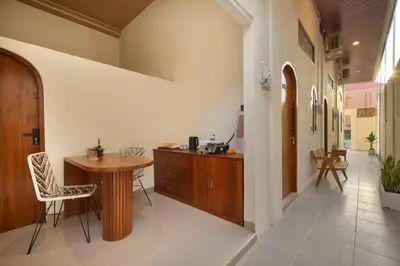 a kitchen with a wooden table and a counter at Cozia Living in Jimbaran