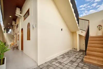 a hallway of a house with white walls and stairs at Cozia Living in Jimbaran