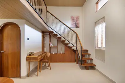 a hallway with a wooden staircase and a wooden desk at Cozia Living in Jimbaran