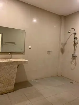 a bathroom with a shower and a sink and a mirror at Marinos Place Legian in Legian