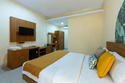 a hotel room with a bed and a television at Cove Raddeyapa in Canggu