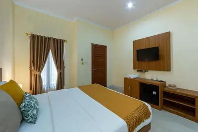 a bedroom with a bed and a flat screen tv at Cove Raddeyapa in Canggu