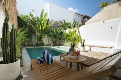 a backyard with a swimming pool with a table and a bench at Villa Teide by BaliSuperHost in Canggu