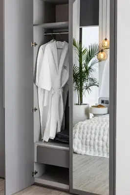 a closet with a white robe on a rack at Brand New Luxury Design Villa by Amare Villas 2 in Badung