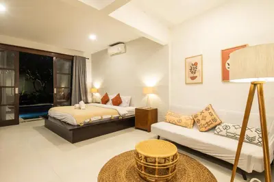 a hotel room with two beds and a couch at Vase 2BR Villa Seminyak in Seminyak