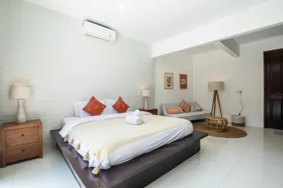 a bedroom with a large bed and a couch at Vase 2BR Villa Seminyak in Seminyak