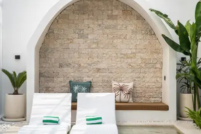 a room with two beds and a brick wall at La Vilaya Villa in Kerobokan