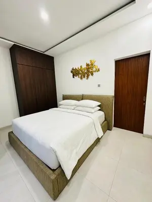 a bedroom with a large bed with wooden doors at Athalia Villa Seminyak in Seminyak