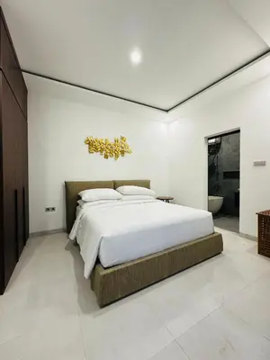 a bedroom with a large bed and a bathroom at Athalia Villa Seminyak in Seminyak