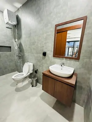a bathroom with a sink and a toilet and a mirror at Athalia Villa Seminyak in Seminyak