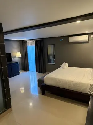 a bedroom with a bed and a television in it at Kooters Guesthouse Bali in Legian