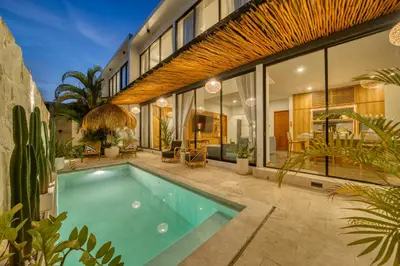 a swimming pool in front of a house at Modern 3bd Tropical Villa with Pool in Central Umalas in Canggu