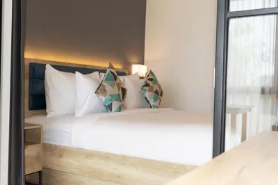 a bedroom with a bed with white sheets and pillows at Anagata Tanjung Benoa 4 in Nusa Dua