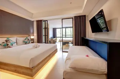 a bedroom with two beds and a flat screen tv at Anagata Tanjung Benoa 4 in Nusa Dua