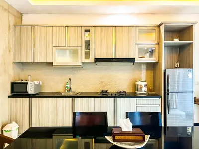 a kitchen with wooden cabinets and a counter top at Ratu Deandra Villa Seminyak in Seminyak