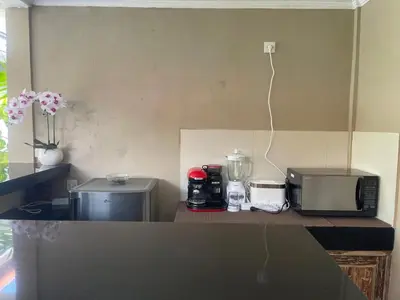 a kitchen with a counter with a microwave and a blender at Sirkus Guesthouse in Canggu
