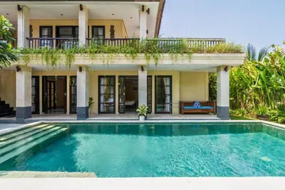 a house with a swimming pool in front of a house at Aileen 4 BR Private Pool Villa in Seminyak