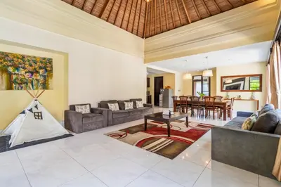 a living room with a couch and a table at Aileen 4 BR Private Pool Villa in Seminyak