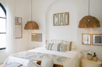 a bedroom with a bed and two pendant lights at Ocean View 4BR Design Villa with Lap Pool & Rooftop Jacuzzi in Jimbaran