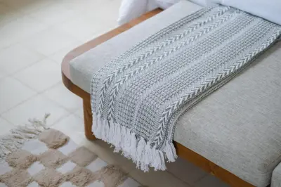 a blanket sitting on the side of a couch at Ocean View 4BR Design Villa with Lap Pool & Rooftop Jacuzzi in Jimbaran