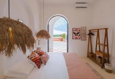 a bedroom with a bed and an open door at Ocean View 4BR Design Villa with Lap Pool & Rooftop Jacuzzi in Jimbaran