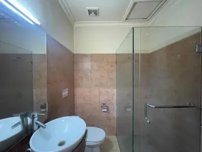 a bathroom with a shower and a toilet and a sink at Puri Samaritan in Denpasar