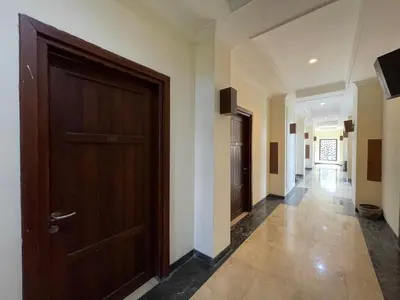 a hallway with a wooden door in a building at Puri Samaritan in Denpasar