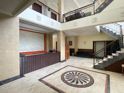 a large lobby with a staircase and a large rug at Puri Samaritan in Denpasar