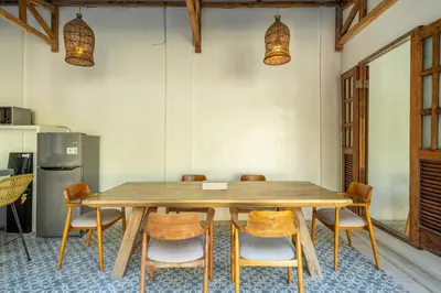 a dining room with a wooden table and chairs at Tuluscoliving Villa Legian 4 Bedrooms and 4 Bathroom in Legian