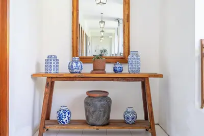a shelf with blue and white vases and a mirror at Tuluscoliving Villa Legian 4 Bedrooms and 4 Bathroom in Legian