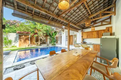 a dining room with a table and a swimming pool at Tuluscoliving Villa Legian 4 Bedrooms and 4 Bathroom in Legian
