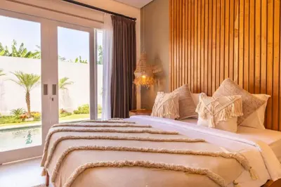 a bedroom with a large bed and a large window at Anatari 3 BR Private Pool Villa in Seminyak