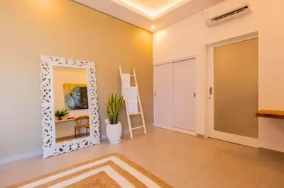a mirror in a room with a table and a chair at Anatari 3 BR Private Pool Villa in Seminyak