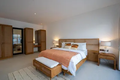a bedroom with a large bed with a wooden headboard at Leva Villa - Luxury 3BR Jimbaran in Jimbaran